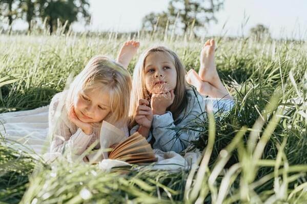 des enfants lisent dans la nature