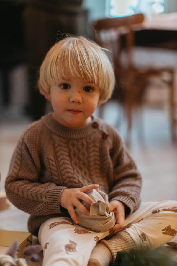 enfant avec un cadeau emballe dans du tissu